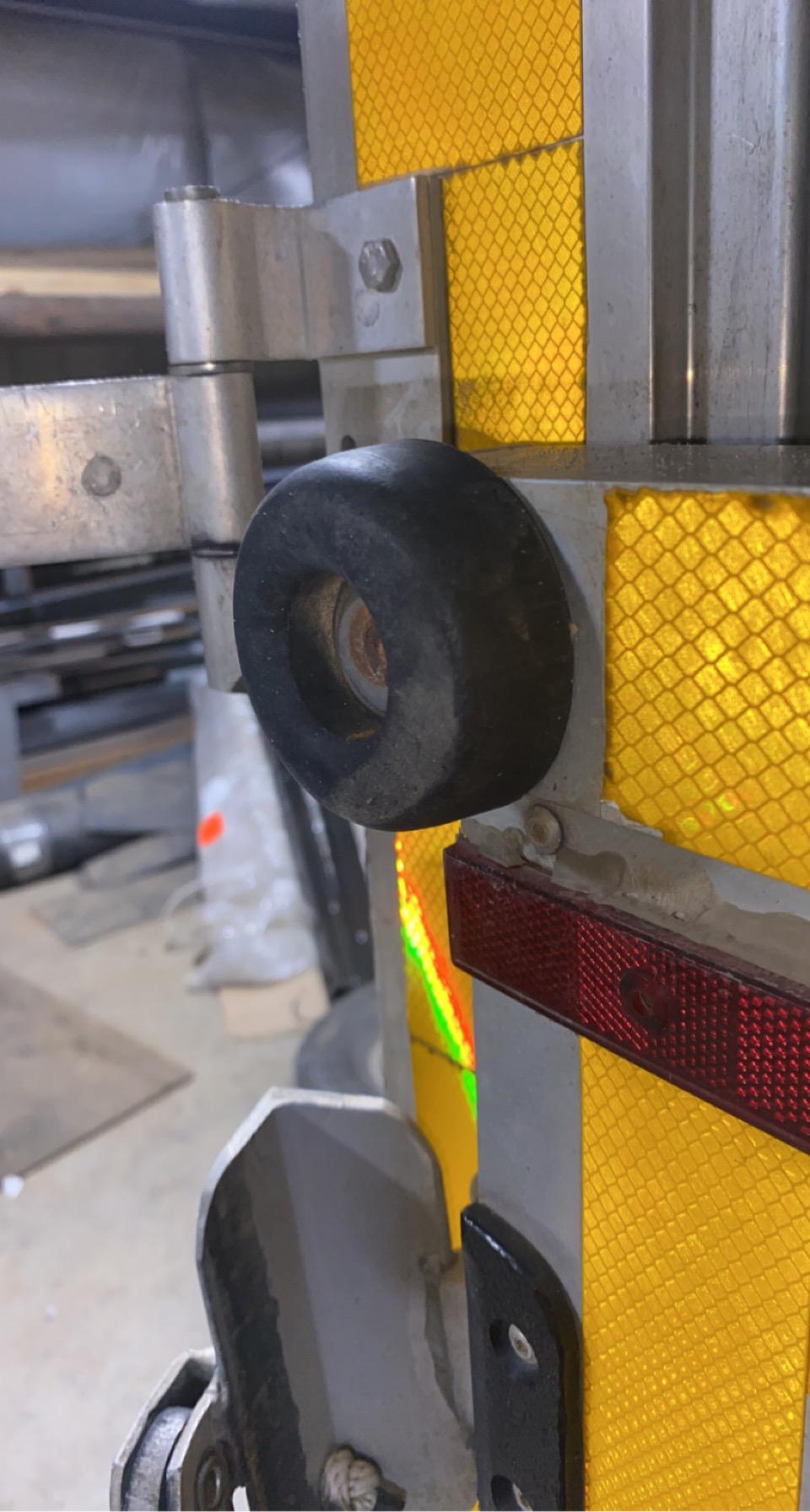 Close up of round rubber bumper on the back of a trailer surrounded by reflective yellow panels.